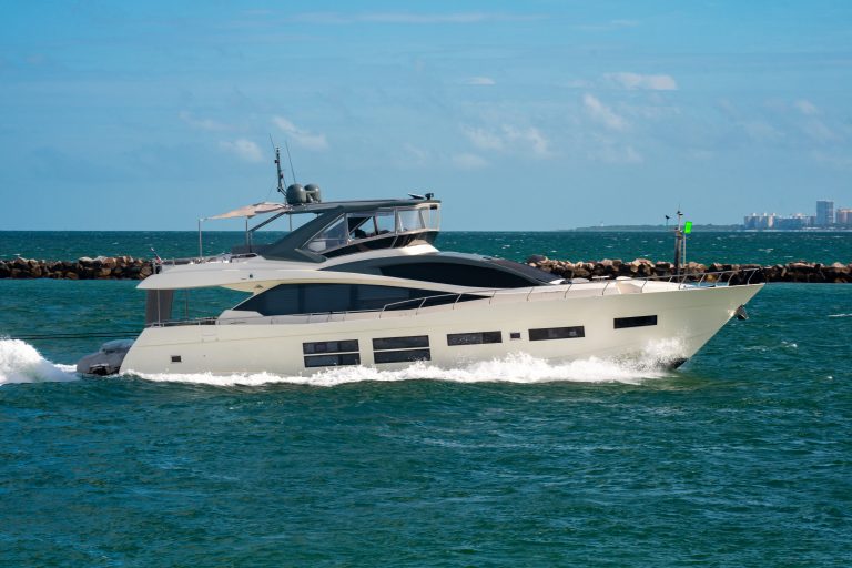 Yacht sailing on sea waters. Luxury superyacht at sea. Miami Beach with yachts. Tropical seascape with a sailboat. Cruise ship near the coastline. Sunset yacht voyage in Florida. Luxury yacht.